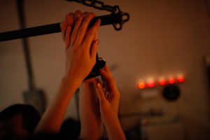Asian Dominatrix Doimina Yuki’s hands affix hand cuffs, preparing for an evening of bespoke fetish and fantasy experience.