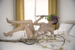 Asian Pro domme Domina Yuki reclines on a bed wearing stilettos invoking thoughts of dark desires and fetish fantasies.